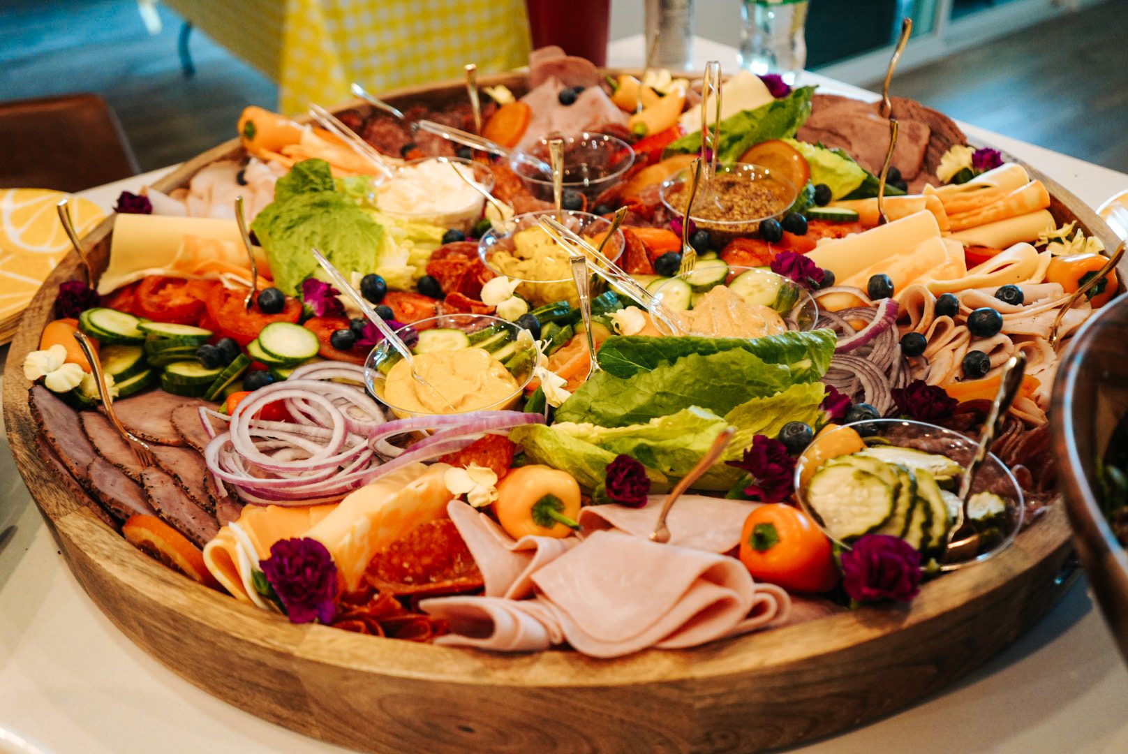 Round charcuterie board with cured meats and vegetables